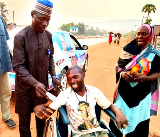 Egbira Musician from Koton-karfe, Kogi local area of Kogi State, Mr. Abdulmumini Abdulkareem (Two-door) after presenting a new wheelchair to Malam Muhamned Ohono
