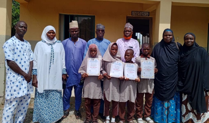 Second right, the head teacher of LEA Islamiyya primary school Kwali, Aisha Yamta Bukar, the LEA secretary of Kwali, Me Philip Peter Leda with the pupils of the school who emerged winner of the Peer Mediation competition in Abuja
