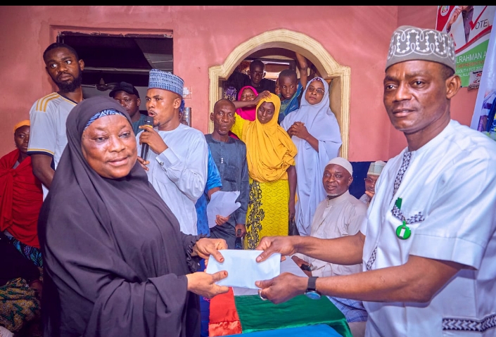 A house of representatives member for Abuja south federal constituency, Alhaji Abdulrahman Ajiya right present cash to one of the beneficiaries of the grant to market women in Abaji on Saturday.