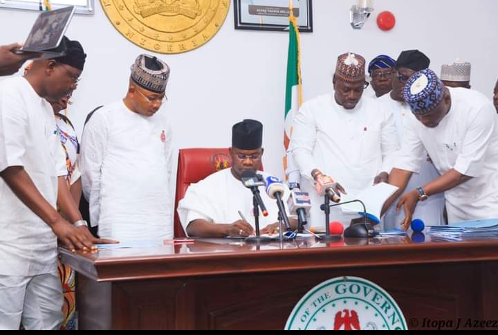Kogi State Governor, Alhaji Yahaya Bello seated signing the 2024 appropriateion Bill into law, Speaker Kogi House of Assembly, Rt. Hon Aliyu Umar (R), Kogi State Governor Elect, Ahmed Usman Ododo and others lawmakers