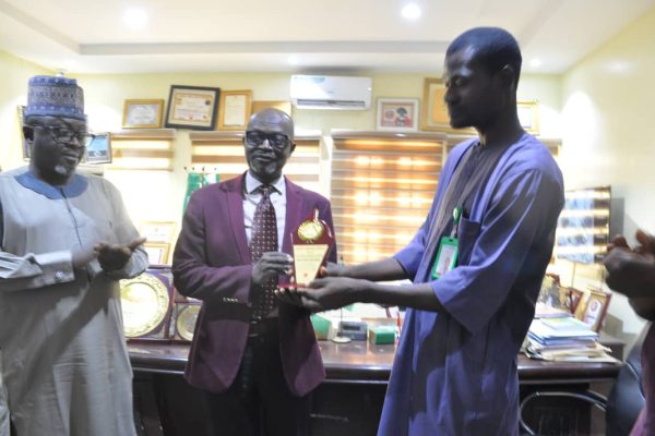 Mr. John Dogo Wada, a state correspondent with the Blueprint Newspaper's Hausa Version, Manhaja presenting an award of merit to the Medical Director, FMC, Keffi.