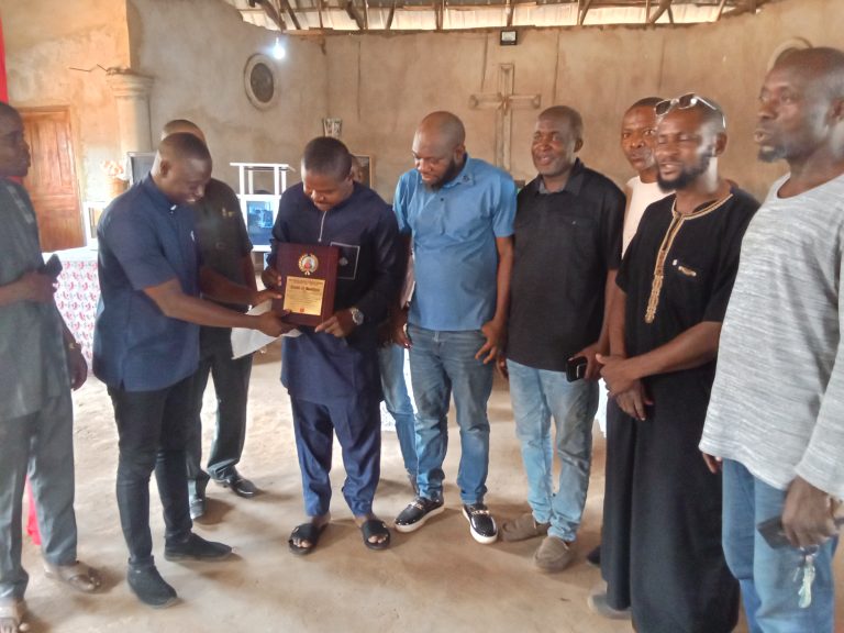 Comrade Benjamin Jeremiah Ojodale, Chairman of the National Youth Council of Nigeria, Kogi State chapter (M) holding the award presented to him, supported by Hon Destiny Keller, the SSA on Youth Mobilisation and NYCN Coordinators from Eastern region of Kogi State