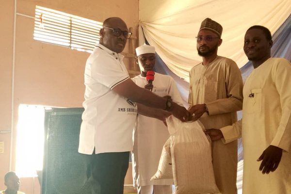 The CEO, ASAF foundation, Ambassador Shehu Adams Adangwe presenting the palliatives to one of the beneficiaries.