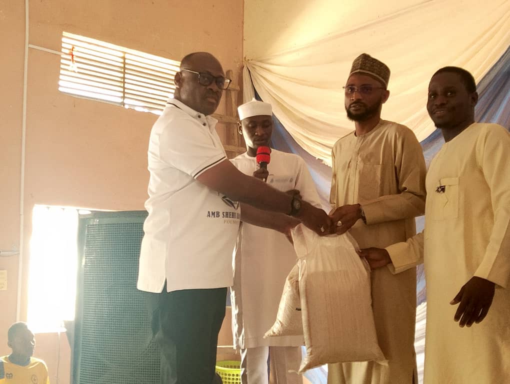 The CEO, ASAF foundation, Ambassador Shehu Adams Adangwe presenting the palliatives to one of the beneficiaries.