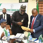 Chief Saviour Enyiekere, PhD (r) receiving the handing over documents from the Secretary to the Commission, Mr Lucky U. Ikharo (l) during the ceremony today.