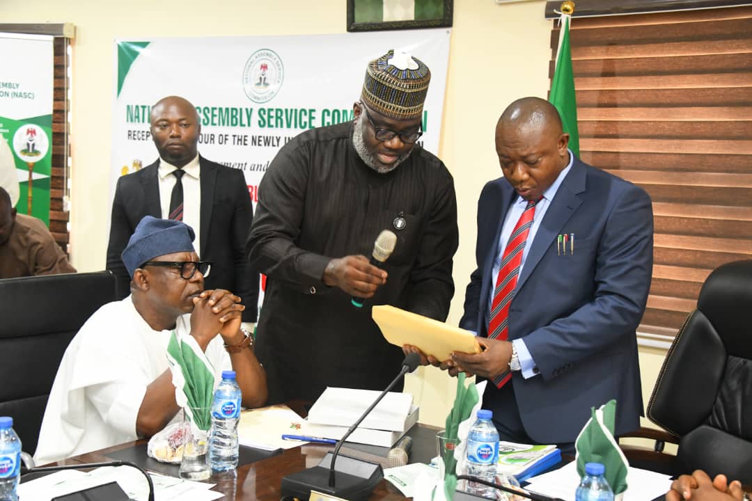 Chief Saviour Enyiekere, PhD (r) receiving the handing over documents from the Secretary to the Commission, Mr Lucky U. Ikharo (l) during the ceremony today.