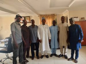 Hon. Barr. Muhammed Musa Tanko Osuku, Chairman Kogi State Civil Service Commission (m) in white, in a group photograph with delegation of former council officials and secretary in the State Civil Service Commission House Lokoja