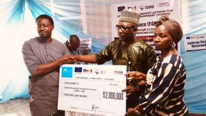 Director CCAPAD presenting dummy check to the beneficiaries.