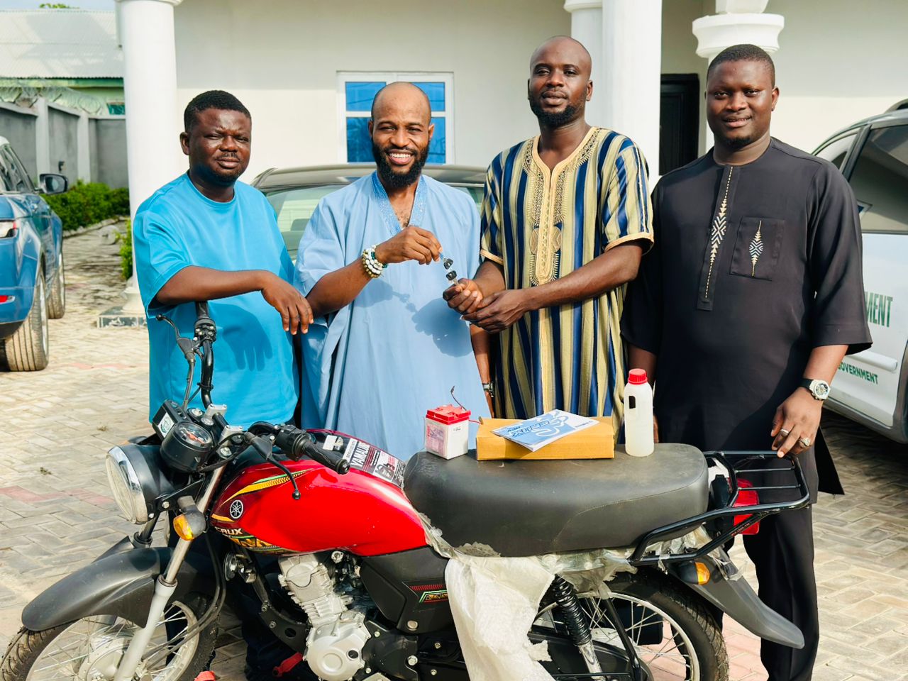 Hon Oladele John Nihi, Founder/CEO of OJN Foundation and Special Adviser on Youth and Student Matters to the Kogi State Governor presenting a brand new motorcycle to Kunle Olupinla