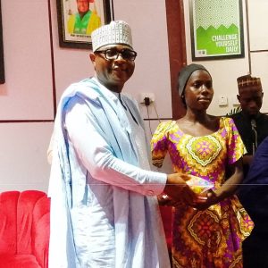 Dr. Maikaya while presenting gift to one of the physically challenged persons at NSUK.