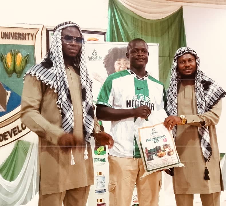 Management team of Faforelife company while presenting gift to one of the beneficiaries.