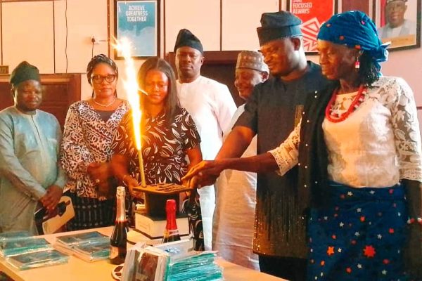 Dr. Monday Abimiku with his family members cutting the birthday cake during his book launch