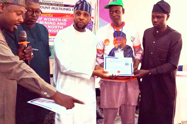 Hon. Gaza, presenting certificate of participation to one of the beneficiaries.