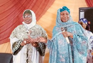 Hajiya Khadijat Abdullahi Adamu presenting the award to prof. Hauwa'u Mainoma for her understanding contribution to women.