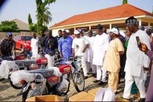 Senator Sunday Karimi's reported donation of an 18-seater bus and six motorcycles to community security groups in Kogi West.